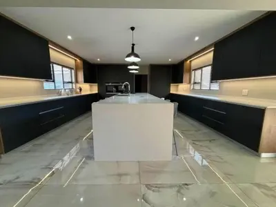 a large kitchen with a white island in the middle at Diamond and Pearl Holiday Home in Hazyview