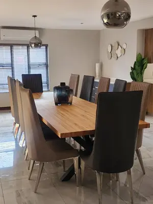 a dining room with a wooden table and chairs at Diamond and Pearl Holiday Home in Hazyview