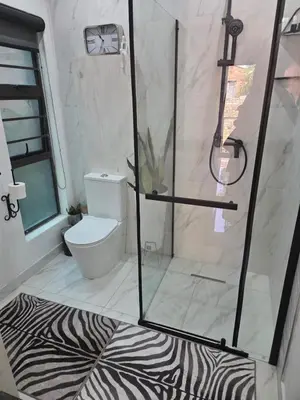 a bathroom with a shower with a zebra print rug at Indulge luxury overnight accommodation in Middelburg