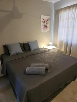 a bedroom with a large bed with two towels on it at Zondereinde Accommodation in Wag ʼn Bietjie Draai