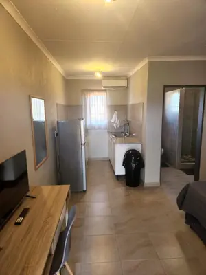 a small kitchen with a refrigerator and a sink at Zondereinde Accommodation in Wag ʼn Bietjie Draai