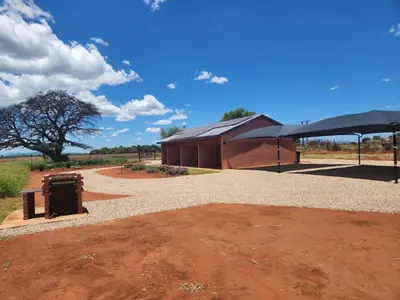 a building with a tent in the middle of a field at Zondereinde Accommodation in Wag ʼn Bietjie Draai