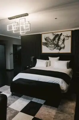 a bedroom with a large bed and a chandelier at Am lodge in Luphisi