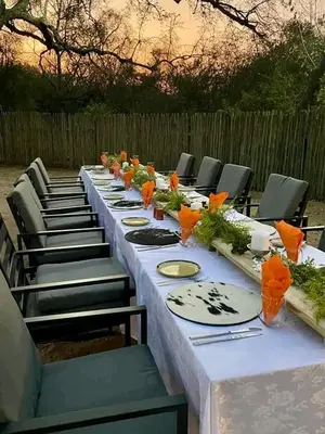 a long table with chairs and plates on it at Am lodge in Luphisi