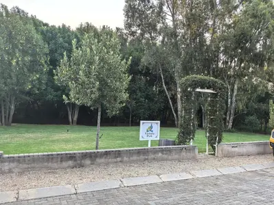 a sign in a park with a tree in the grass at Your Perfect Escape with Breathtaking Lake Views in Pretoria