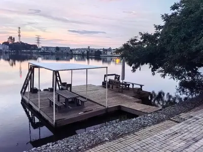 a dock with a table and benches on the water at Your Perfect Escape with Breathtaking Lake Views in Pretoria