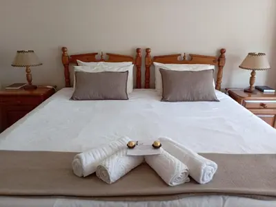 a bed with two pairs of towels on it at Bloemhoek Guest House in Centurion