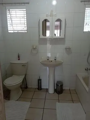 a white bathroom with a sink and a toilet at Bloemhoek Guest House in Centurion
