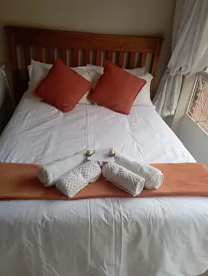 a bed with two towels and two pillows on it at Bloemhoek Guest House in Centurion