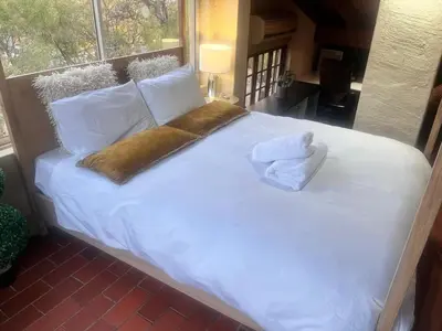 a large white bed with two towels on it at Executive loft at Brooklyn in Pretoria