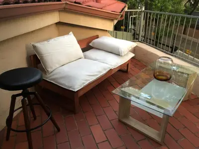 a couch and a table on a balcony with a glass coffee table at Executive loft at Brooklyn in Pretoria