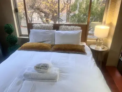 a white bed with towels on it with a window at Executive loft at Brooklyn in Pretoria