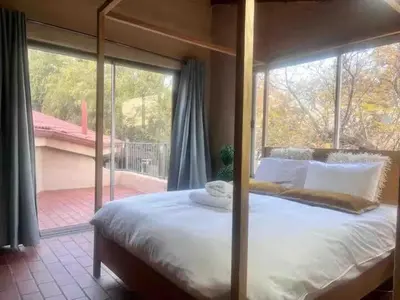 a bedroom with a large bed with a large window at Executive loft at Brooklyn in Pretoria