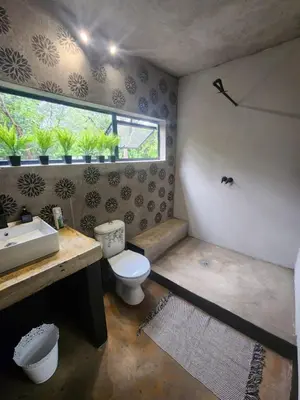 a bathroom with a toilet and a sink and a window at Hartbeest Bush Stay #5 in Hartbeespoort