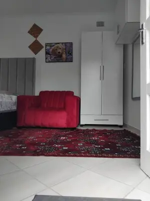 a red couch in a living room with a red rug at Claremont Secured Residence in Pretoria