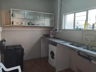 a kitchen with a sink and a washing machine at Claremont Secured Residence in Pretoria