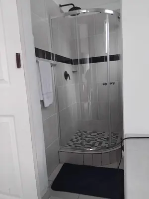 a bathroom with a shower with black and white tile at Claremont Secured Residence in Pretoria