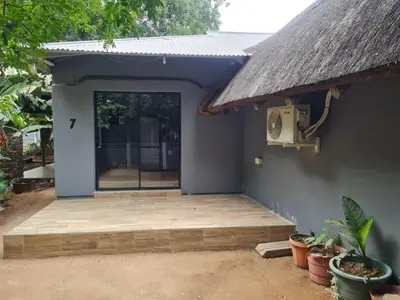 a small house with a wooden porch and a door at Shabi's Guest Lodge in Phalaborwa