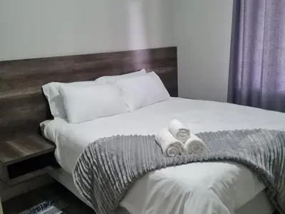 a bed with two rolled towels on top of it at Shabi's Guest Lodge in Phalaborwa