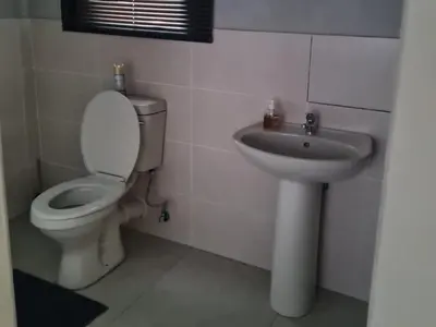 a bathroom with a toilet and a sink at Shabi's Guest Lodge in Phalaborwa