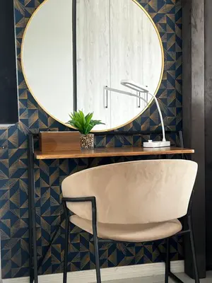 a mirror on a wall above a desk with a chair at The Sactuary in Midrand
