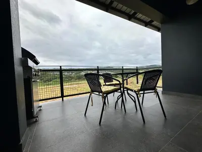 a table and chairs on a balcony with a view at MAYAMUYE Lifestyles in Nelspruit