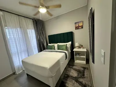 a bedroom with a large bed with a ceiling fan at MAYAMUYE Lifestyles in Nelspruit