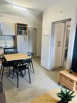 a kitchen and dining room with a table and chairs at Calm & Cozy Apartment in Pretoria