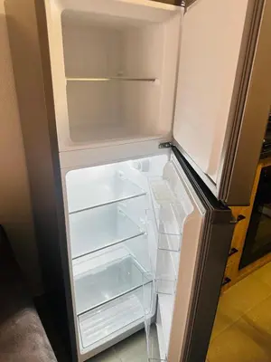 an empty refrigerator with its door open in a kitchen at Calm & Cozy Apartment in Pretoria