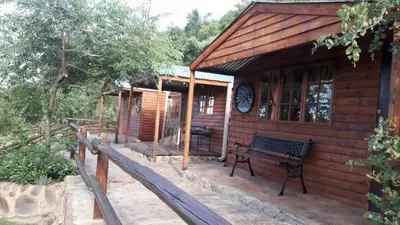 a wooden cabin with a bench in front of it at Inniberg Nylstroom Chalets in Modimolle