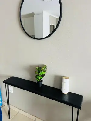a black table with a mirror and a plant on it at Hartmanz Laxury Apartments in Pretoria