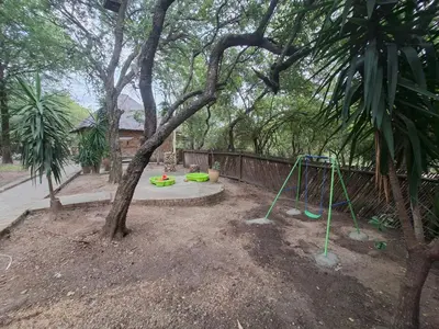 a playground with a tree and a swing set at Ratel Retreat in Marloth Park