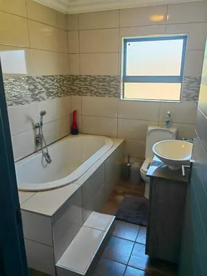 a bathroom with a tub and a toilet and a sink at XLA Home-Luxury in Witbank