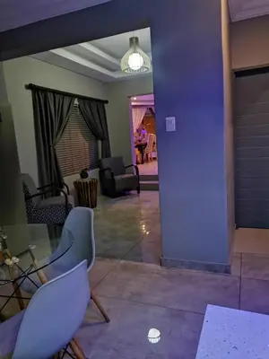 a living room with a glass table and chairs at XLA Home-Luxury in Witbank