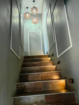 a stairway with wooden steps and two chandeliers at XLA Home-Luxury in Witbank