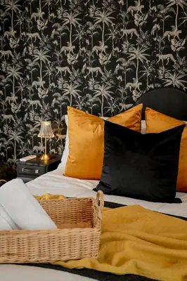 a bed with orange pillows and a black and white wallpaper at Reveuse in Pretoria