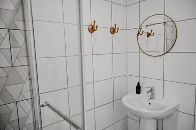 a white bathroom with a sink and a mirror at Reveuse in Pretoria