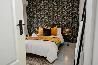 a bedroom with a bed and a black and white wallpaper at Reveuse in Pretoria