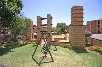 a sculpture in a yard with two brick towers at VH Apartments have fun with us in Midrand