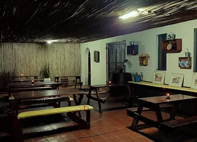 a room with wooden tables and benches in it at Canimambo at The Old Post Office Inn in Graskop