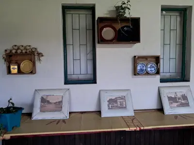 a room with four windows and pictures on the wall at Canimambo at The Old Post Office Inn in Graskop