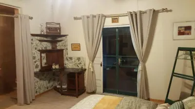 a living room with a large glass door with curtains at Canimambo at The Old Post Office Inn in Graskop