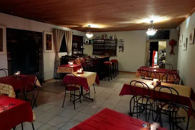 a restaurant with red tables and chairs in a room at Canimambo at The Old Post Office Inn in Graskop