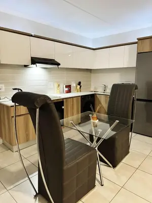 a kitchen with a glass table and two chairs at Joe's The Blyde in Pretoria