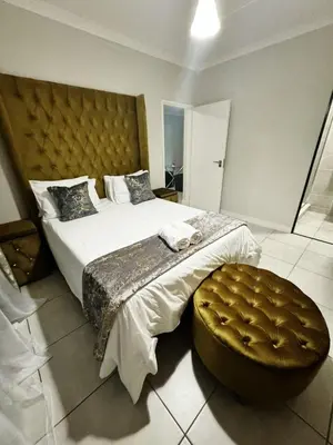a bedroom with a large bed with a tufted headboard at Joe's The Blyde in Pretoria
