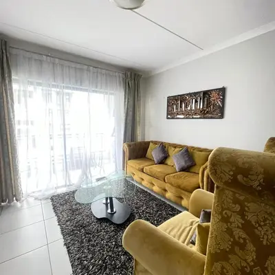 a living room with a couch and a glass table at Joe's The Blyde in Pretoria