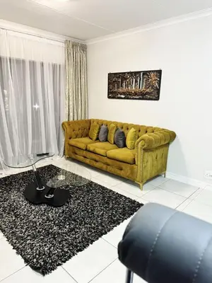 a living room with a yellow couch and a rug at Joe's The Blyde in Pretoria