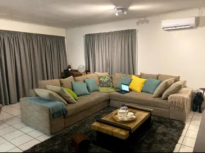 a living room with a brown couch with colorful pillows at Tendani Full-House in Centurion