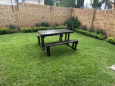 a picnic table sitting in the grass in a yard at Tendani Full-House in Centurion