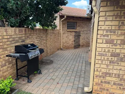 a barbecue grill in front of a brick wall at Tendani Full-House in Centurion